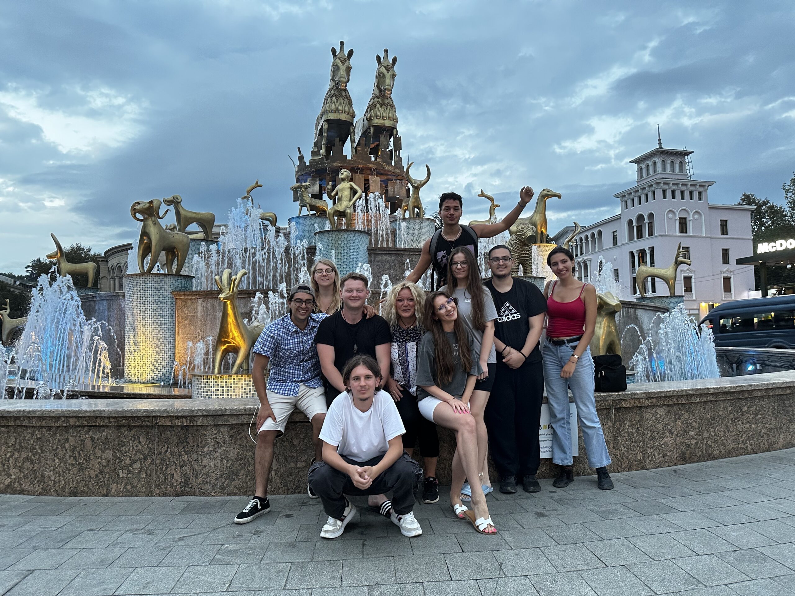 Zdjęcie grupy osób na tle fontanny