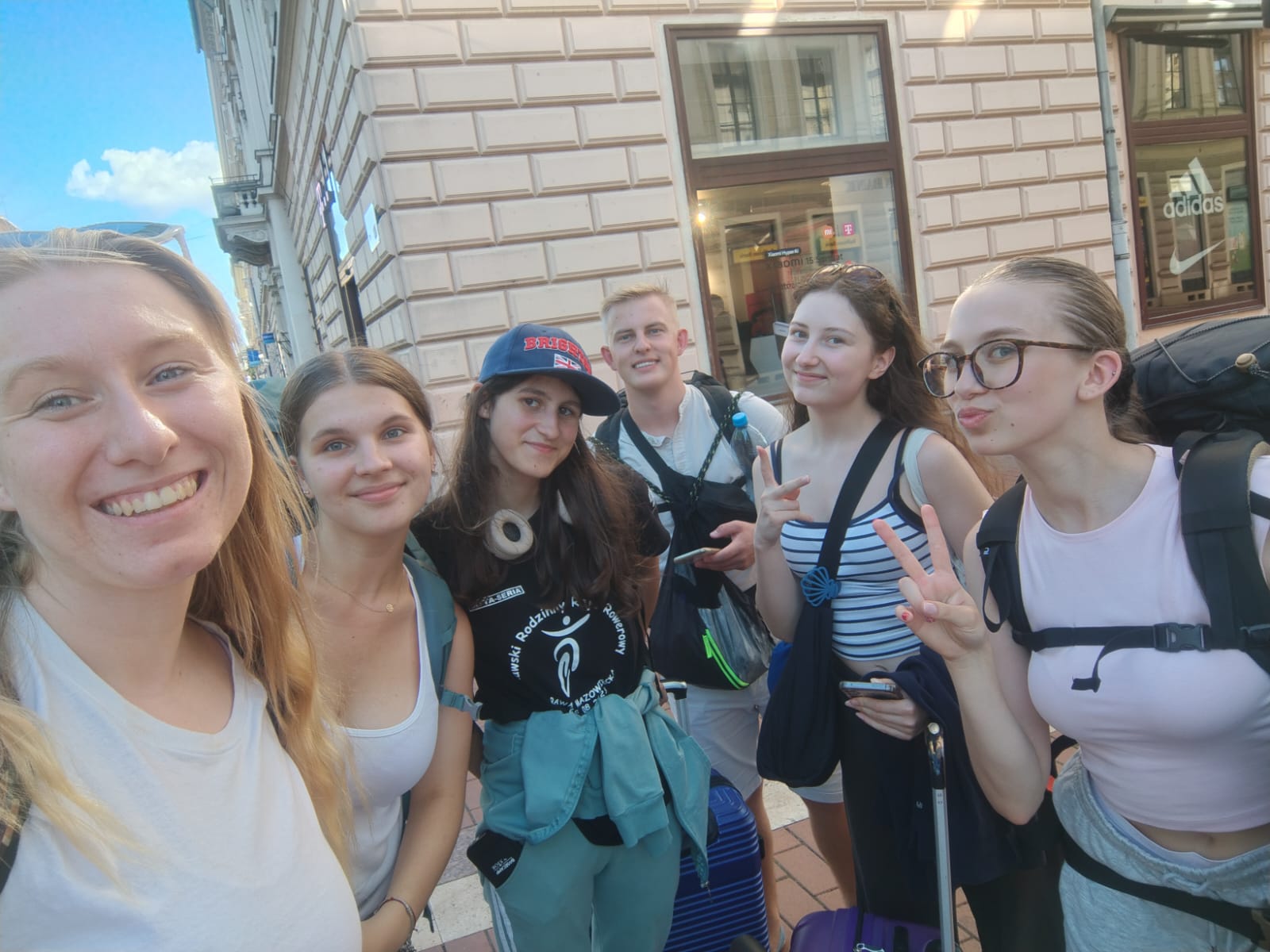 Grupa osób przed budynkiem z cegły